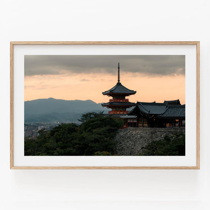 Framed photo titled Kiyomizu-dera Sunset II featuring a traditional Japanese pagoda at sunset with mountains in the background.