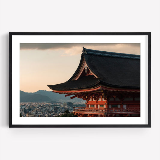 Framed photograph titled Kiyomizu-dera Sunset III depicting a traditional Japanese temple with a cityscape and mountains in the background.