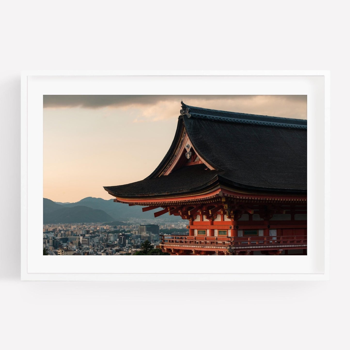 Kiyomizu-dera Sunset III: A traditional Japanese temple roof with a cityscape and mountains in the background during sunset.