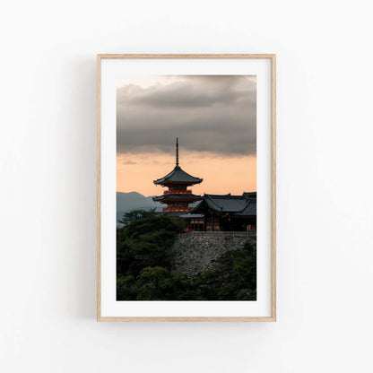 Kyoto Allure - Set of 3: Framed photo of a Japanese temple with a pagoda against a cloudy sunset sky.