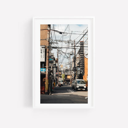 Framed Kyoto Allure photo set: Urban street scene with power lines, buildings, and a white vehicle on a sunny day.