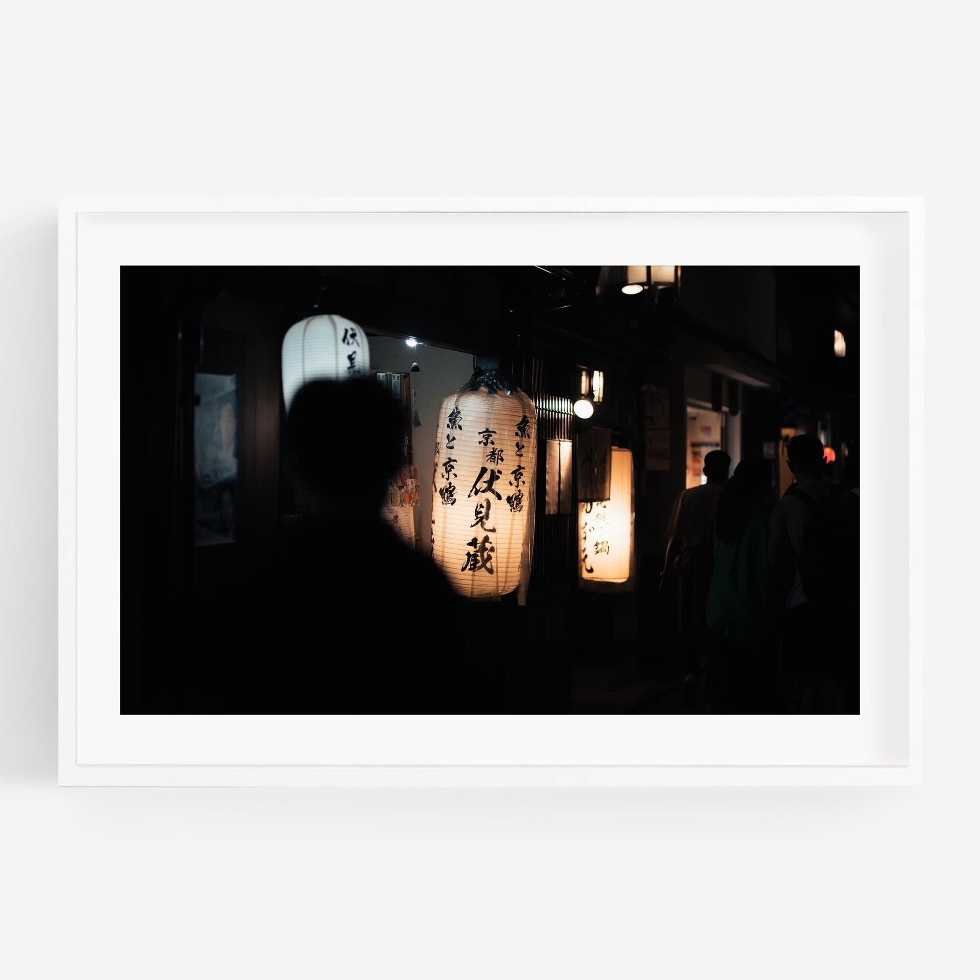 A silhouetted figure strolls past glowing lanterns adorned with Japanese characters in the product Kyoto At Night.