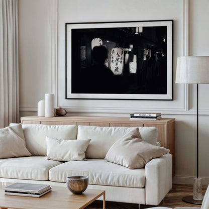 A modern living room features a beige sofa, pillows, a floor lamp, and the framed photo Kyoto At Night - Black and White on the wall.