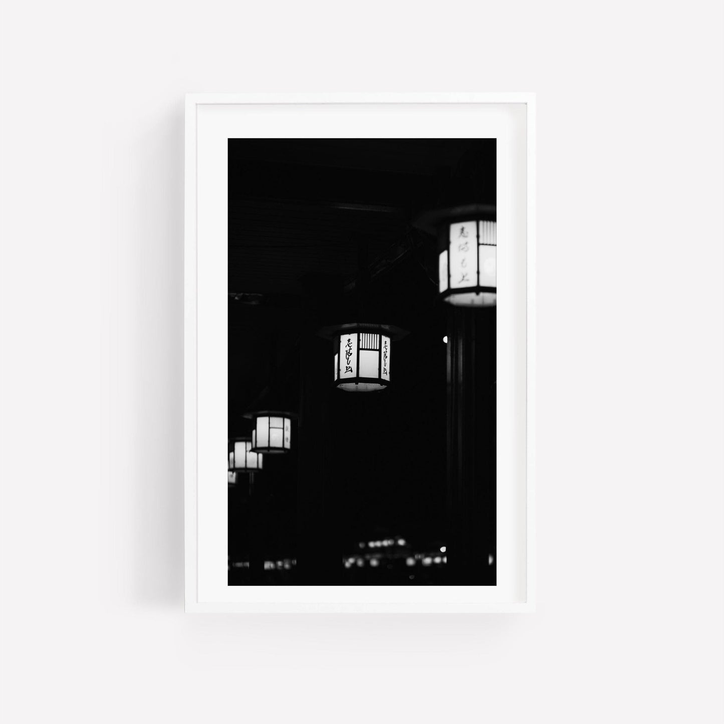 Kyoto Lanterns II - Black and White features an illuminated hanging lantern with Japanese characters set against a dark backdrop.