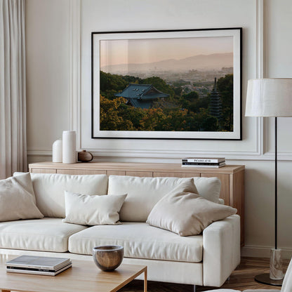 A cozy living room with a white sofa, wooden sideboard, and the Kyoto Sunset Skyline I framed photograph on the wall.