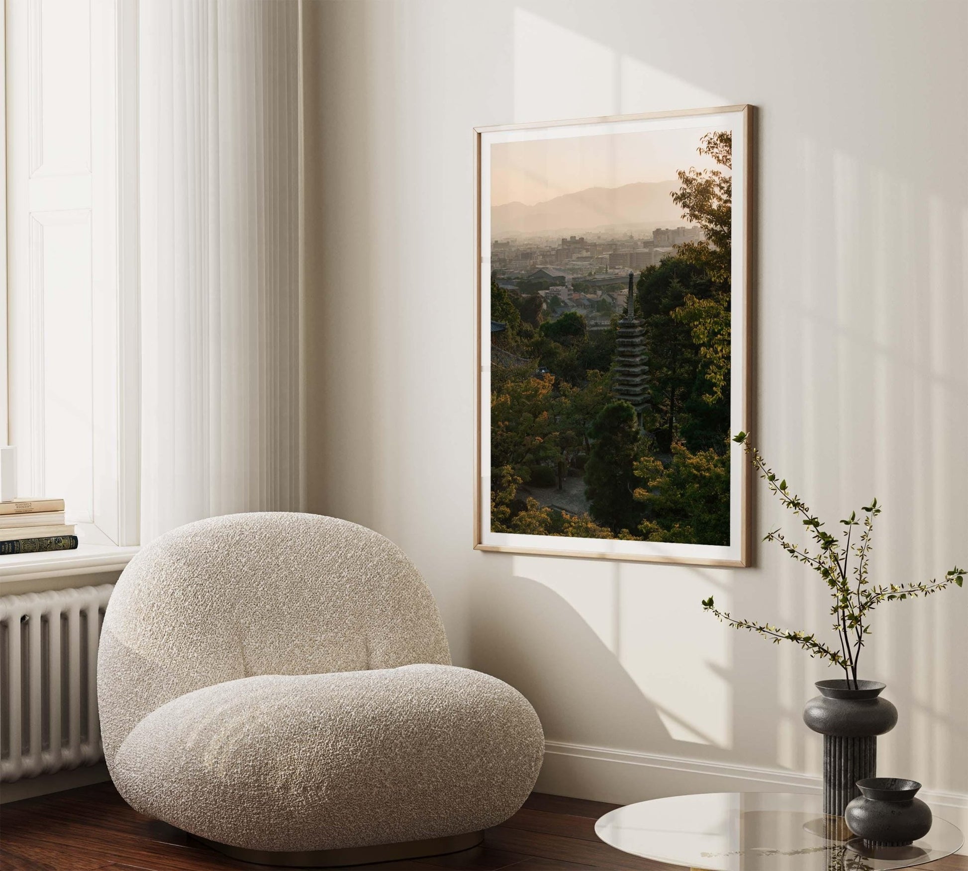 Cozy room featuring a soft chair, plant, and the framed Kyoto Sunset Skyline II photo on the wall. Natural light flows through a tall window.