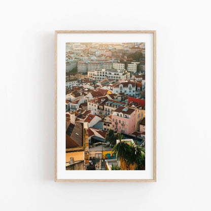 Lisbon Layers: Framed cityscape photo with colorful buildings and red rooftops on a white wall.