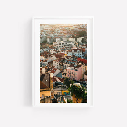 Lisbon Layers: Framed cityscape photo of red-roofed buildings in soft sunlight on a white wall.