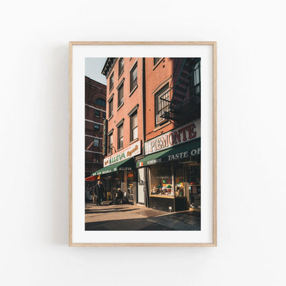 Framed photo Little Italy shows the Alleva and Taste of Piemonte storefronts on a sunny street.