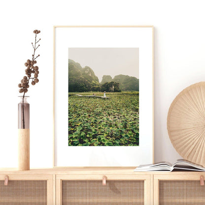 Lotus Lady photo, framed on a wooden shelf beside a vase and an open book.