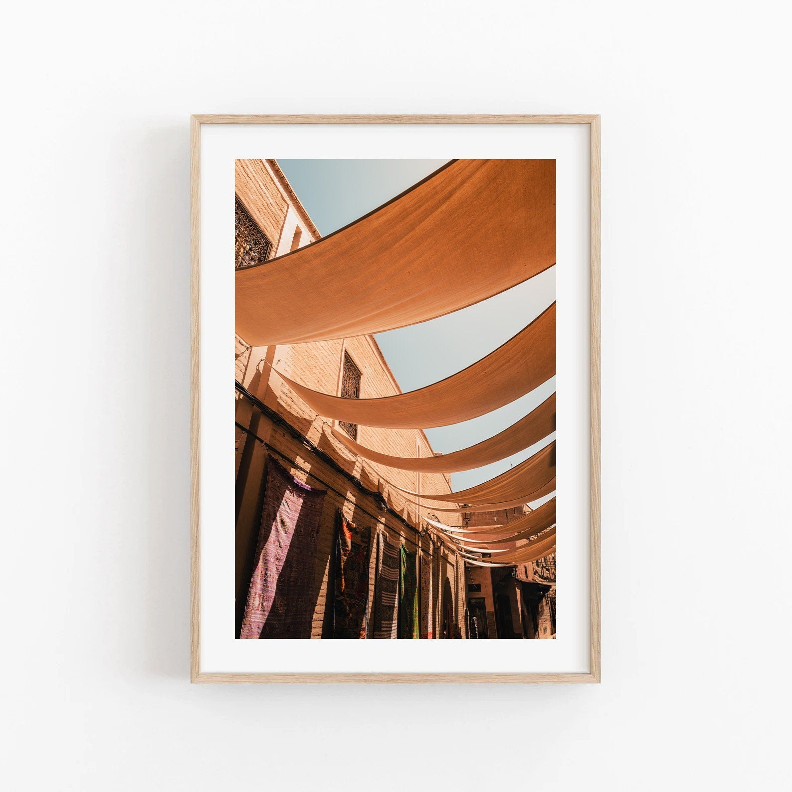 Framed photo of Marrakesh Souk II with canopies, hanging textiles, and a clear blue sky.