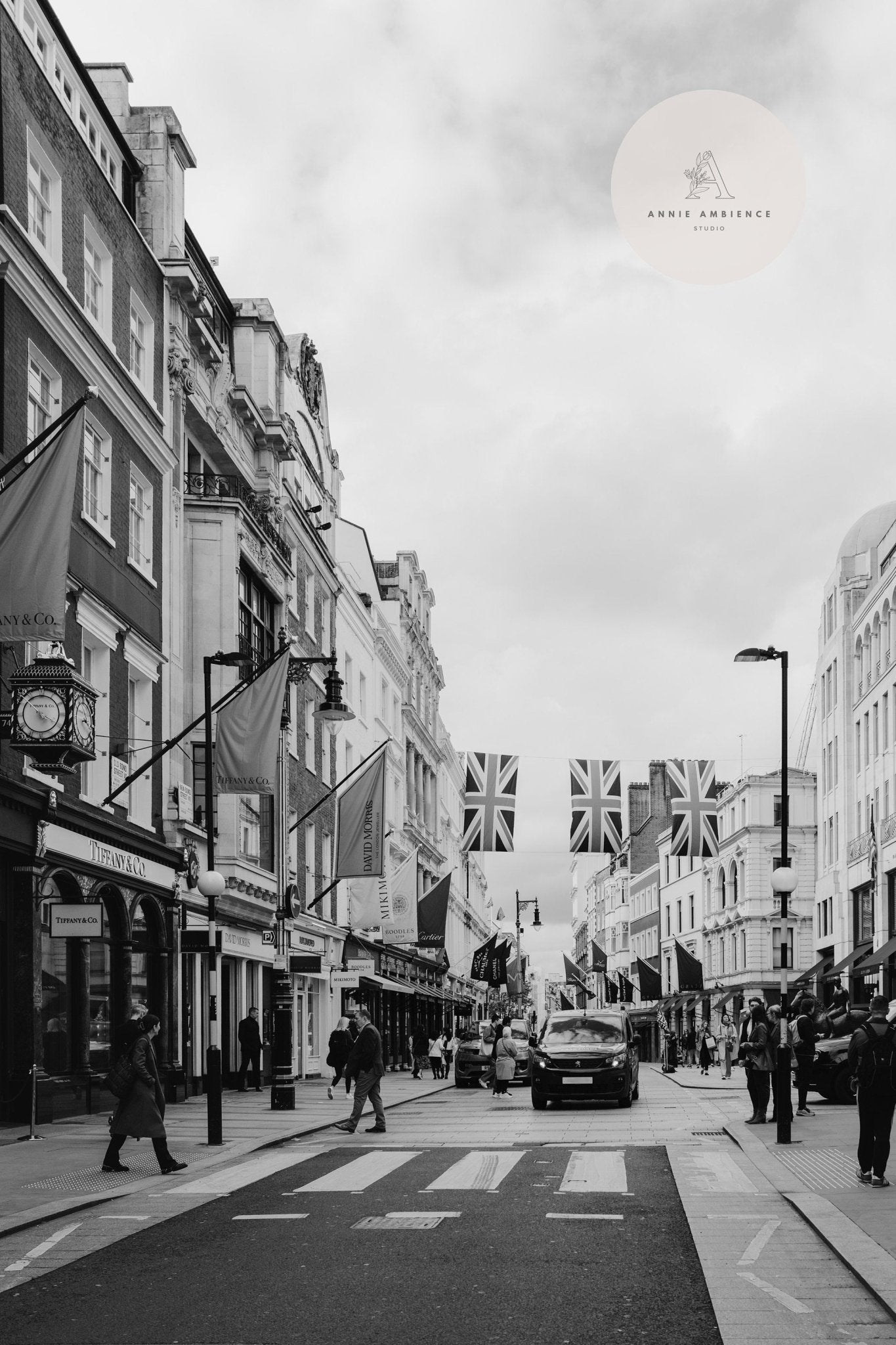 Mayfair Black and White: street scene with pedestrians, vehicles, Union Jack flags above, surrounded by buildings.