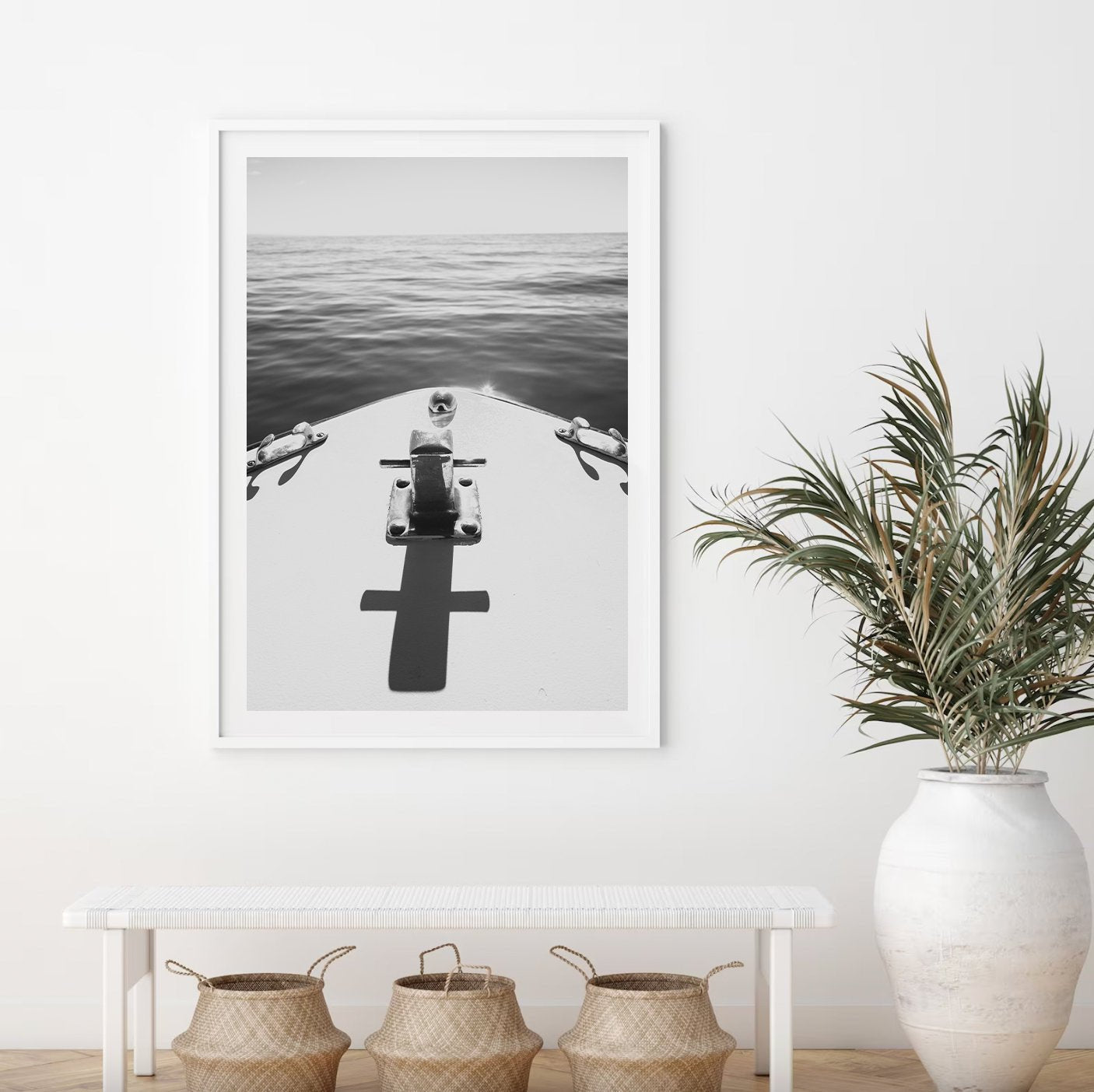 Midday Cruise Black and White photo of a boats bow on calm water, framed above a bench with wicker baskets and a plant.