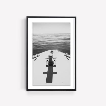 Framed Midday Cruise Black and White photo of a boats bow displayed on a white wall, resting on calm water.