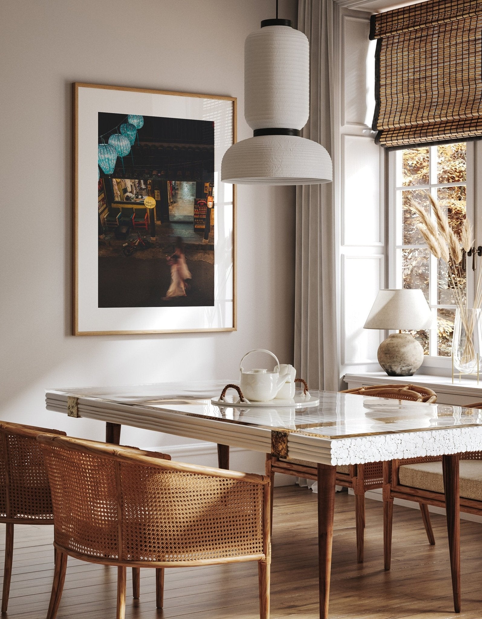 A cozy dining room with wicker chairs, a white marble table, a pendant light, and Midnight Memories artwork on the wall.