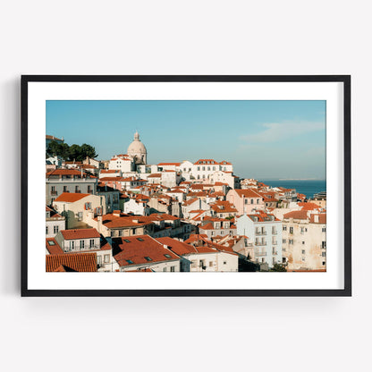 Miradouro: Framed photo of a coastal cityscape with red rooftops, white buildings, and a domed church.