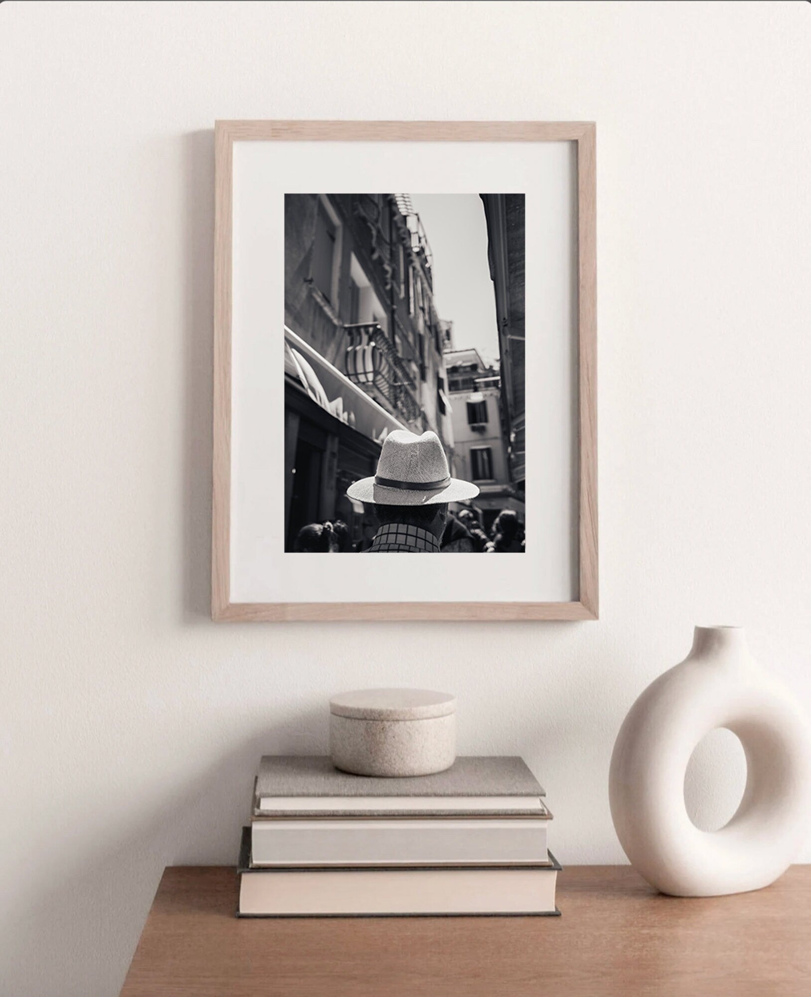 Mystery Man Black and White photo framed on a neutral wall above a wooden dresser with decor.