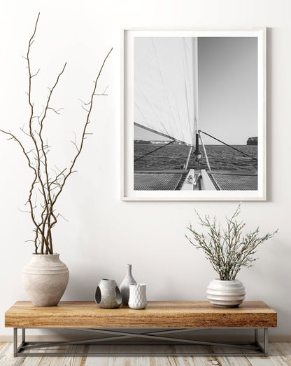 Minimalist decor with vases on a wooden shelf beneath the Nautical Harmony Black and White sailboat photo.