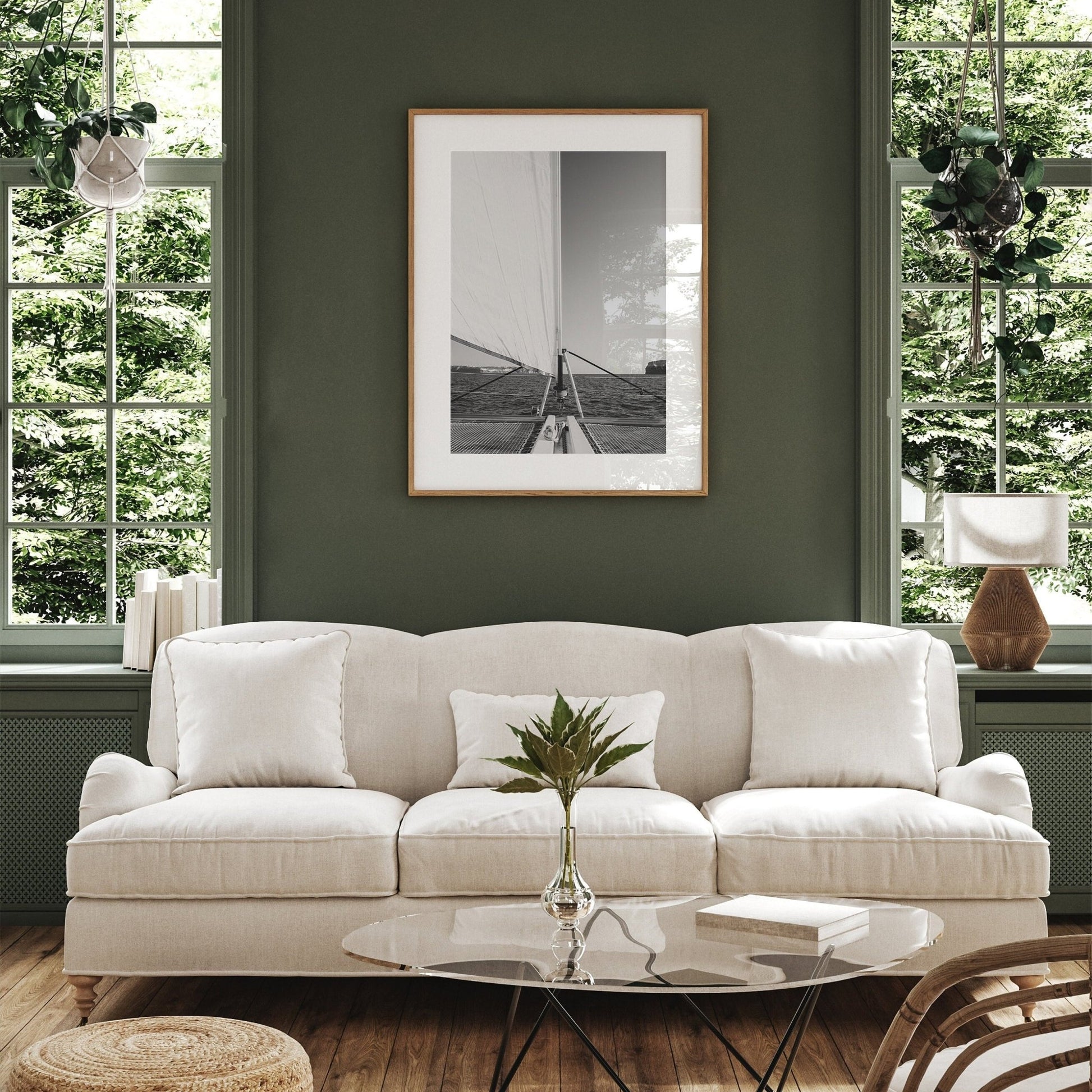 Living room featuring a beige sofa, green walls, large windows with greenery outside, glass coffee table & Nautical Harmony photo.