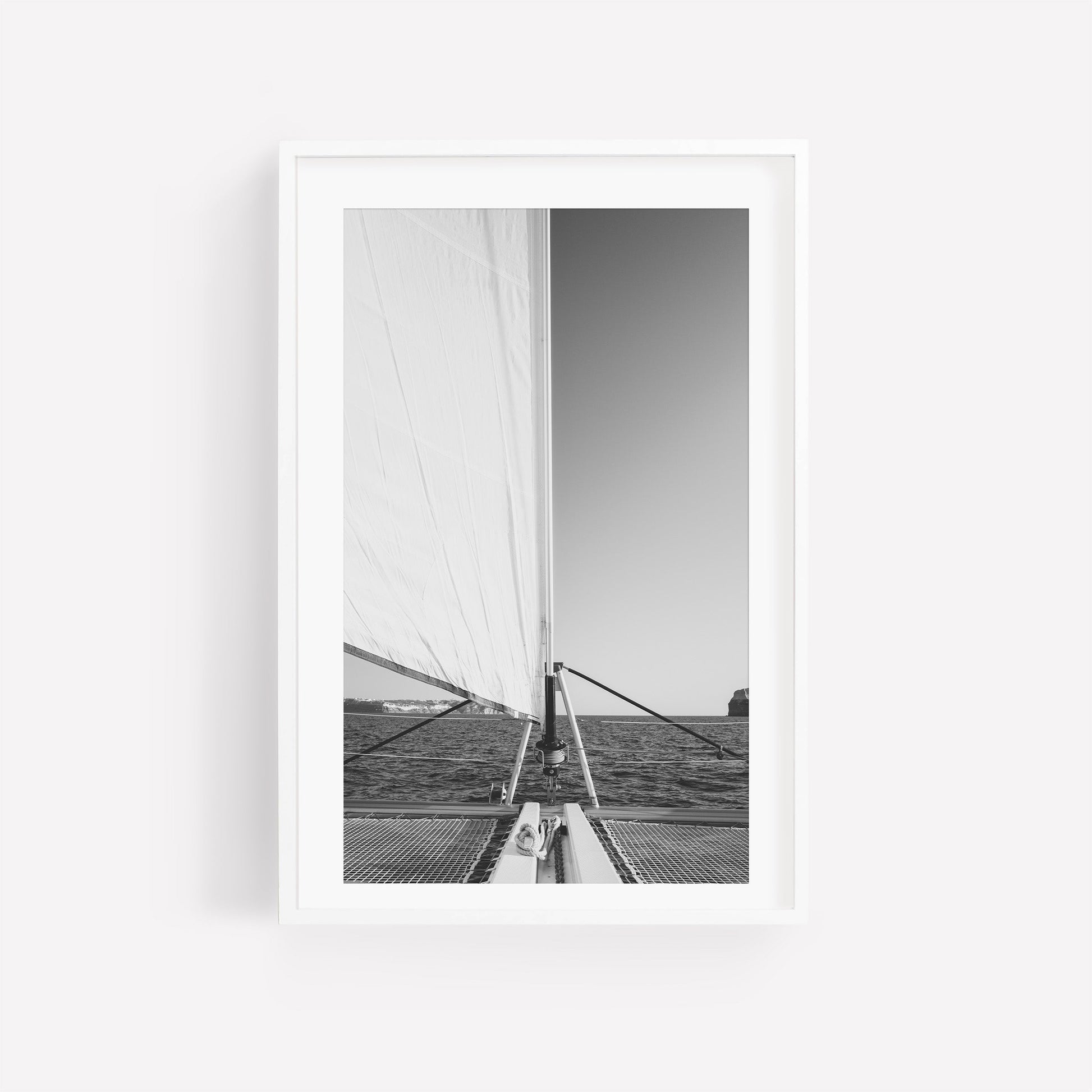 Nautical Harmony Black and White photo of sailboat with large sail; distant horizon, framed in white.