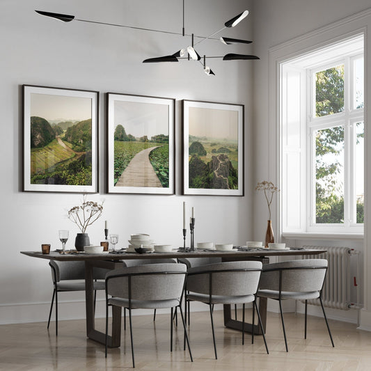 Modern dining room featuring the Ninh Binh - Set of 3 sleek table, gray chairs, large window, and landscape artwork.