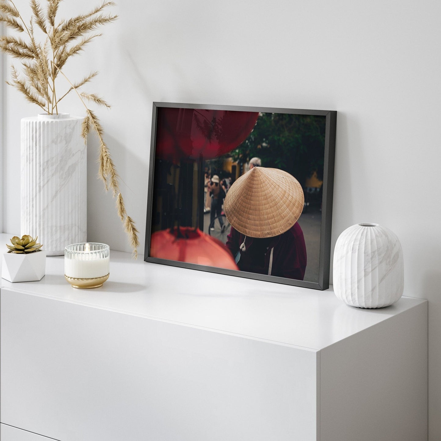 Nón Lá photo on white cabinet, with decorative vases and plants.