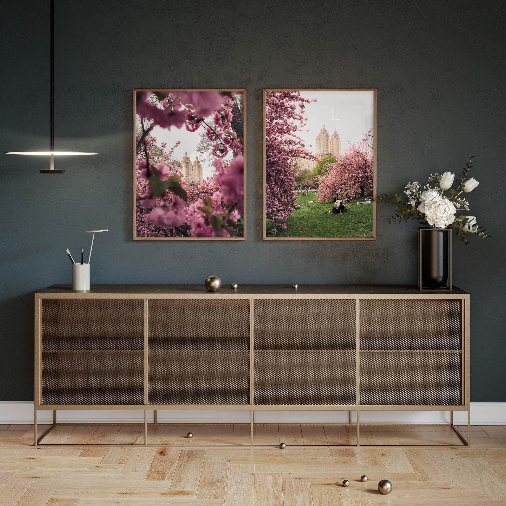 Modern sideboard with decor sits below NYC Cherry Blossoms - Set of 2 on a dark wall in a stylish living space.