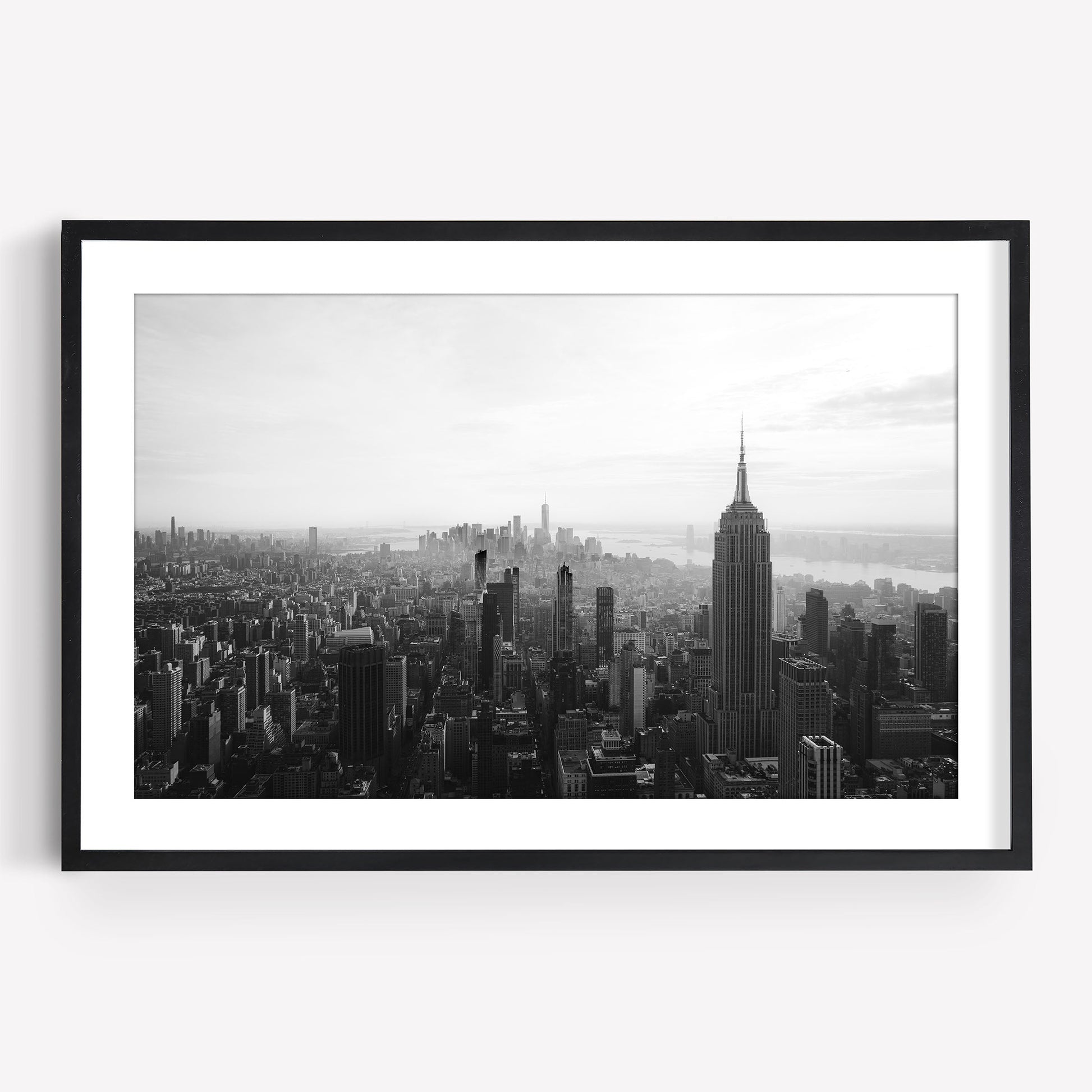 NYC Skyline Black and White framed photo of the Empire State Building on a white wall.