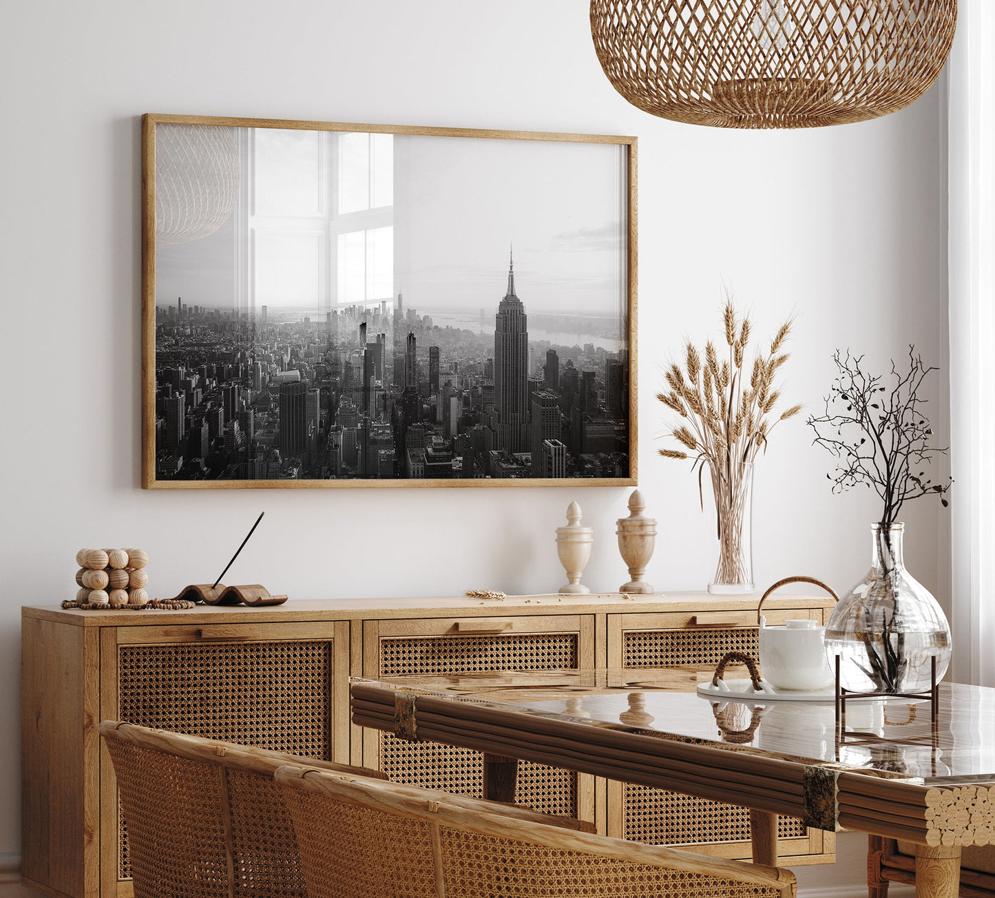 Dining room with rattan furniture, a glass table, and the NYC Skyline Black and White photo on the wall.