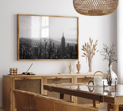Dining room with rattan furniture, a glass table, and the NYC Skyline Black and White photo on the wall.