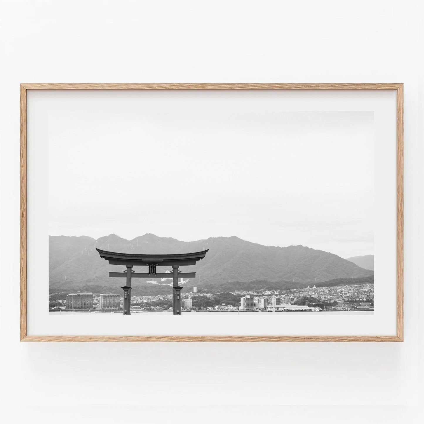 Black and white image titled O-Torii Gate features a torii gate with mountains behind, elegantly framed in light wood.