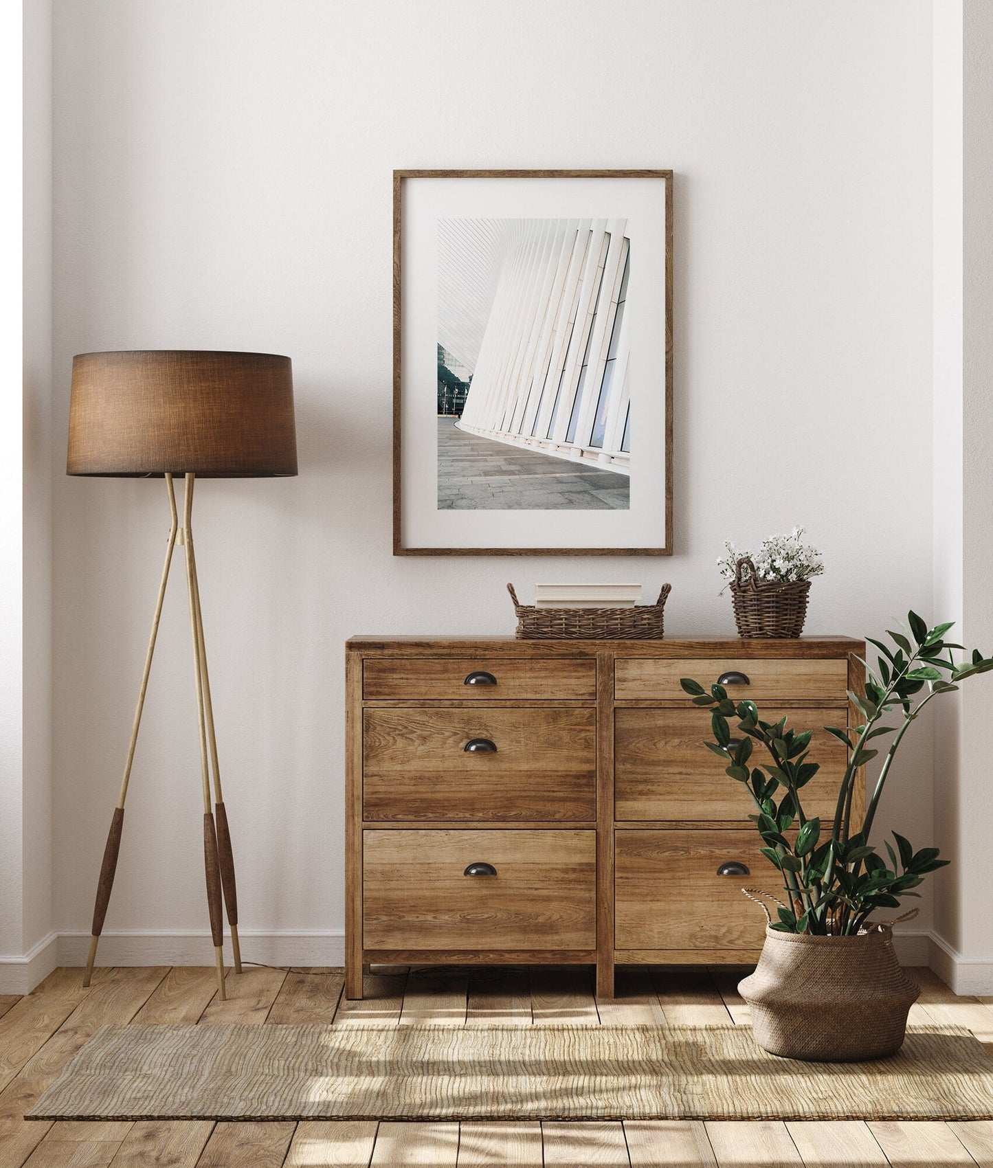 A wooden dresser with a lamp and plant beside it, featuring a framed image on a white wall. Product: Oculus.