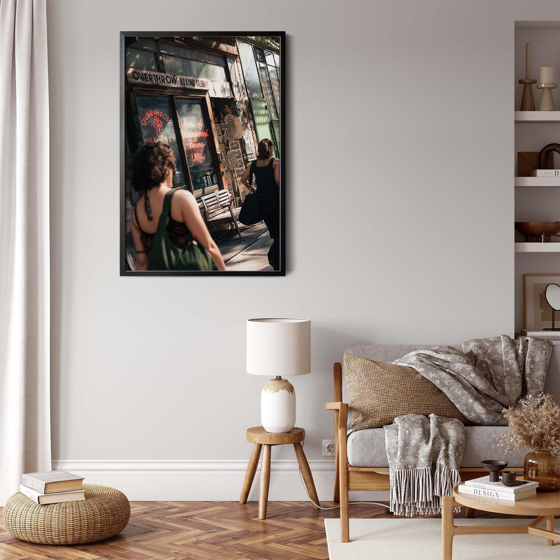 Stylish living area with neutral tones, a large framed Overthrow Boxing Club print, modern decor, and greenery.