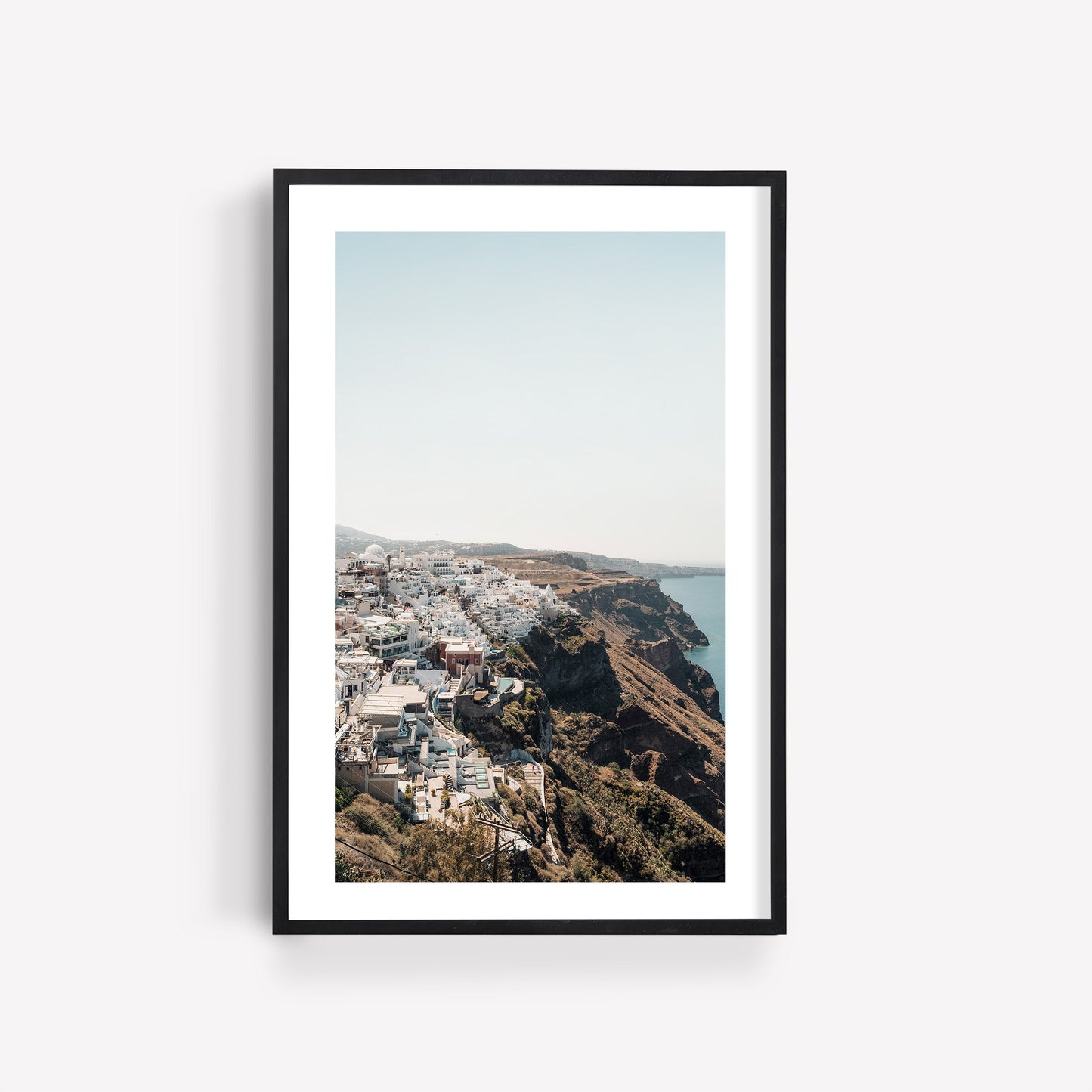 Perched: Framed photo of a seaside town with white cliffside buildings overlooking blue water and clear skies.