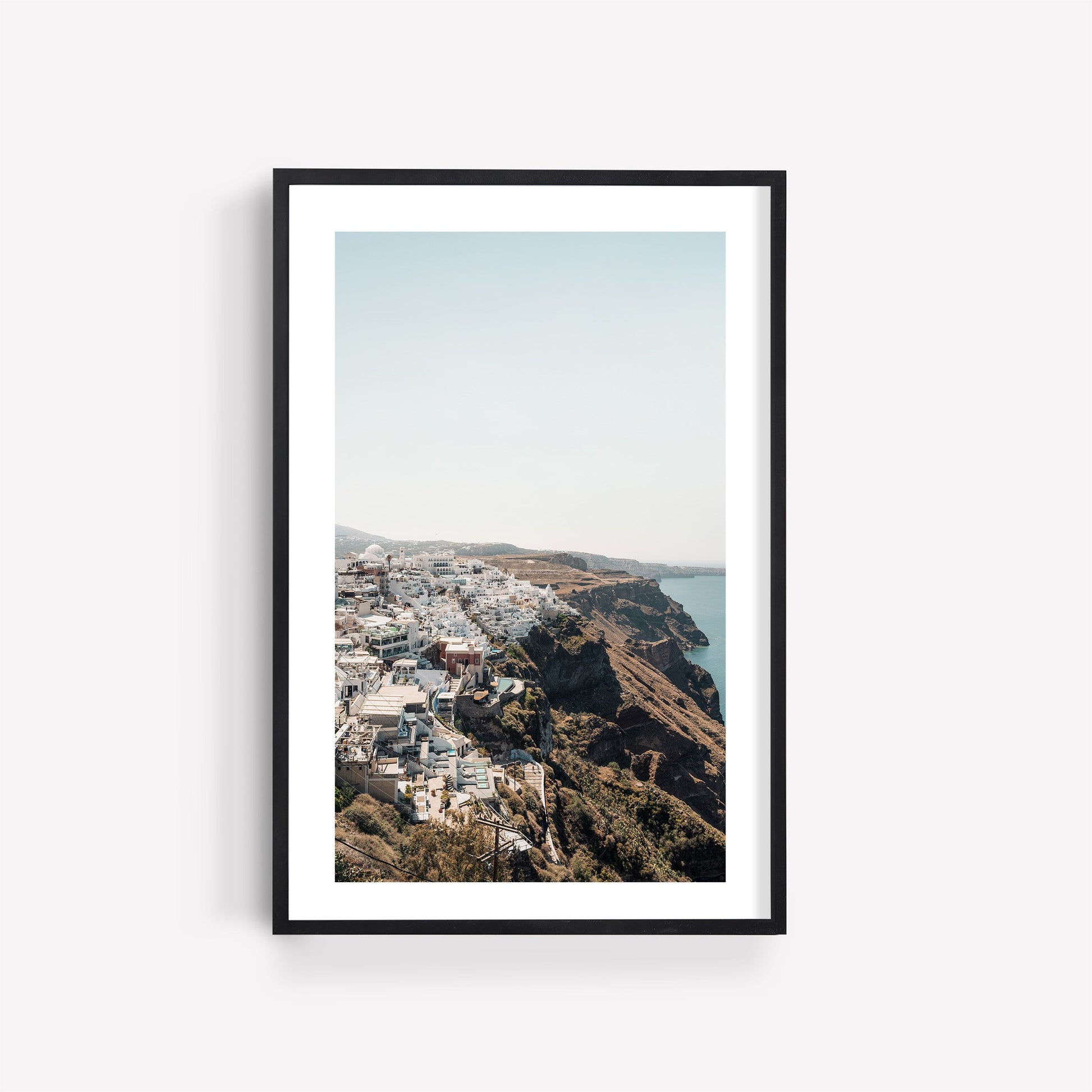 Perched: Framed photo of a seaside town with white cliffside buildings overlooking blue water and clear skies.