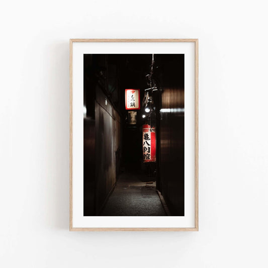 Pontocho Alley is a framed photograph capturing a narrow, dimly-lit alley adorned with glowing Japanese signs.