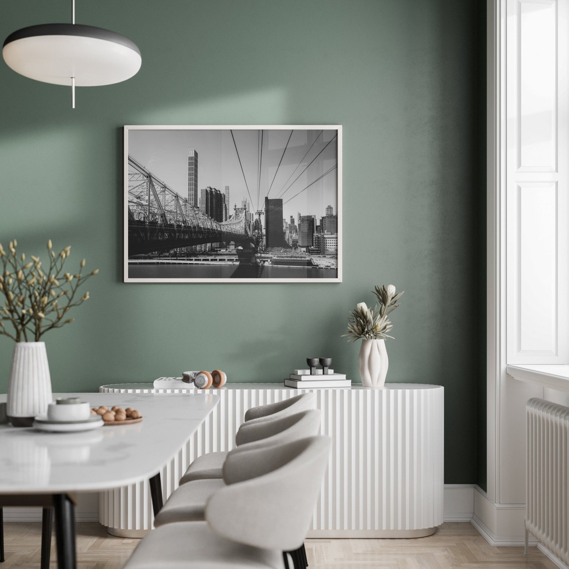 Minimalist dining room with a green wall, Queensboro Bridge Black and White photo, and light furniture.