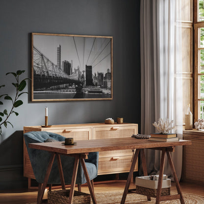 Stylish home office with a wooden desk, chair, and cabinet, featuring Queensboro Bridge Black and White photo on the wall.