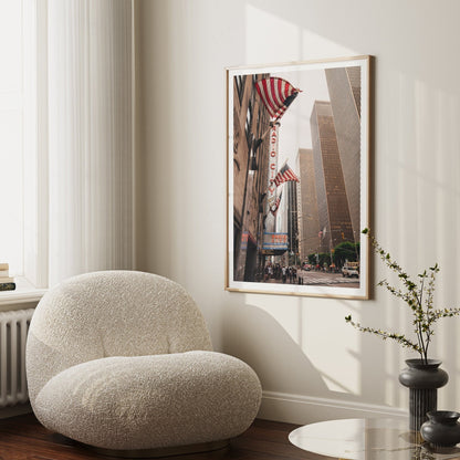 Cozy room with a plush chair and a framed Radio City Music Hall photo on the wall.