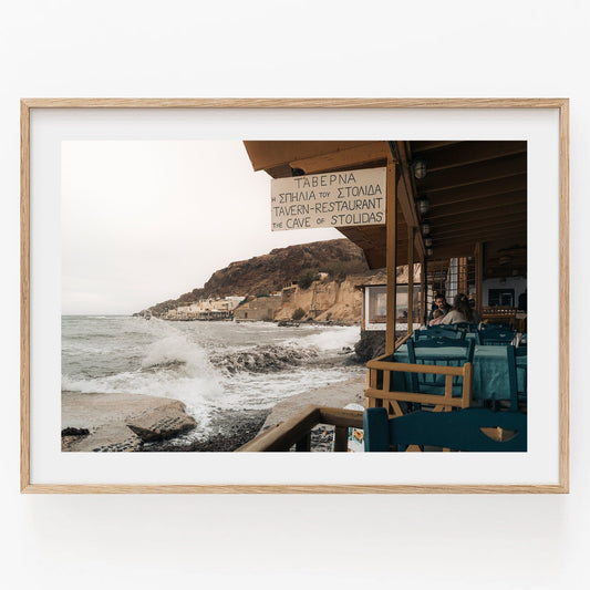 Framed Rainy Day photo of a seaside tavern with waves crashing on a rocky shore under an overcast sky.