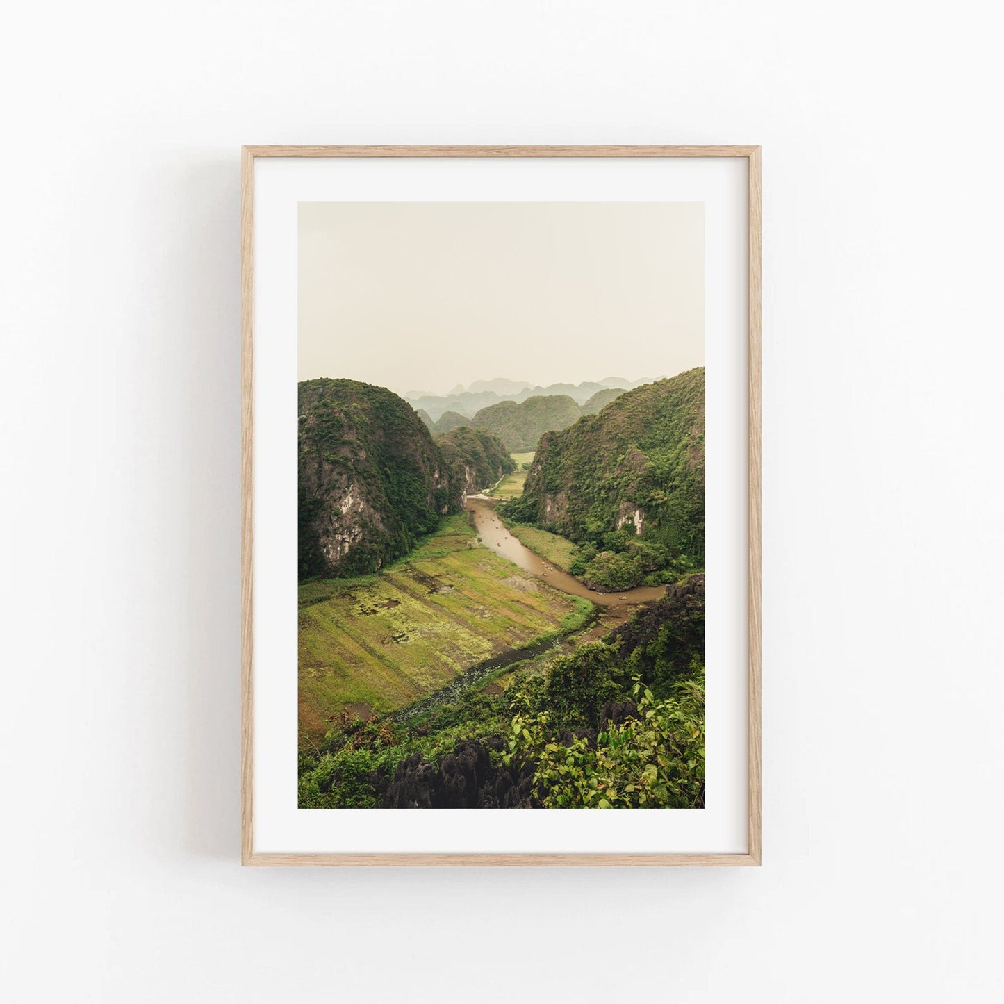 The River Valley framed photo shows a lush green valley with a river on a neutral wall.