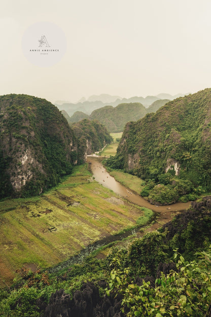 A scenic view of River Valley with a river winding through forested hills under a cloudy sky.