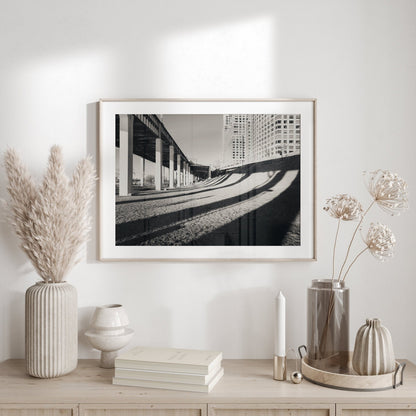 Riverside Shadow Black and White photo hung above a wooden console with vases, pampas grass, and books.