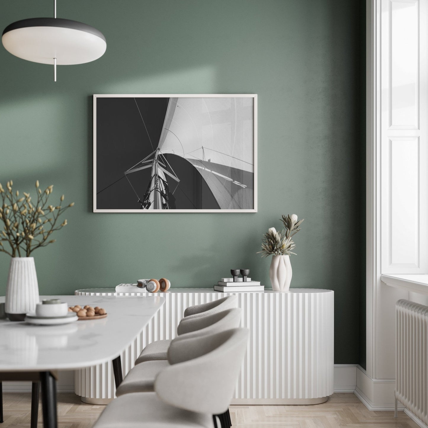 Minimalist dining room with green walls, a modern table, chairs, and Sailing Bliss Black and White artwork on the wall.