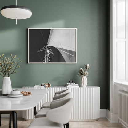 Minimalist dining room with green walls, a modern table, chairs, and Sailing Bliss Black and White artwork on the wall.