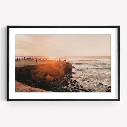 Sunset Cliffs photo of a sunset over the ocean with people on rocks, framed in black.