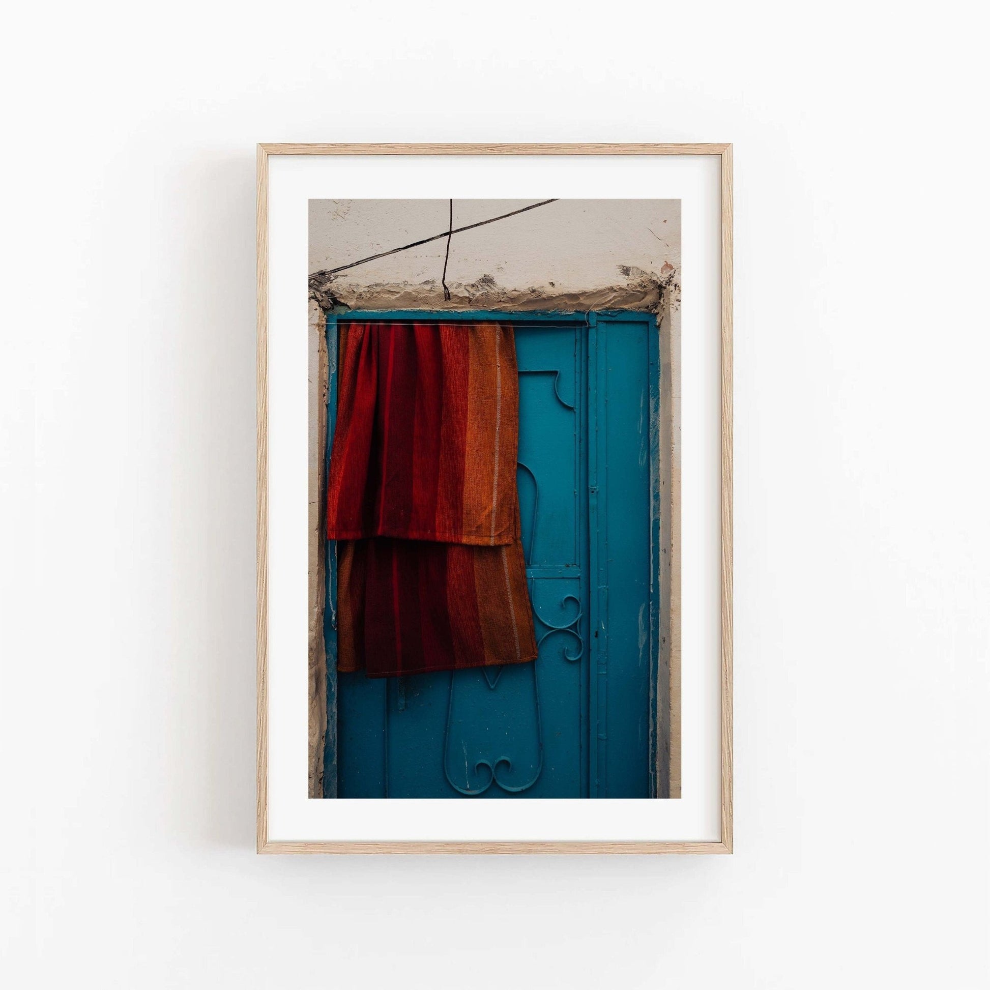 A framed photo titled Taghazout Door shows a blue door draped with red-orange fabric.
