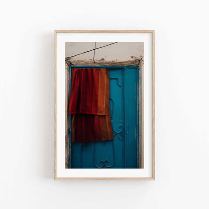 A framed photo titled Taghazout Door shows a blue door draped with red-orange fabric.
