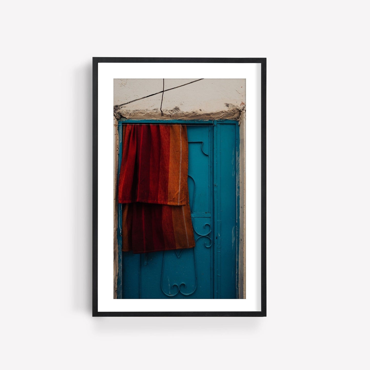 Framed Taghazout Door photo featuring a blue door with a red-orange cloth.
