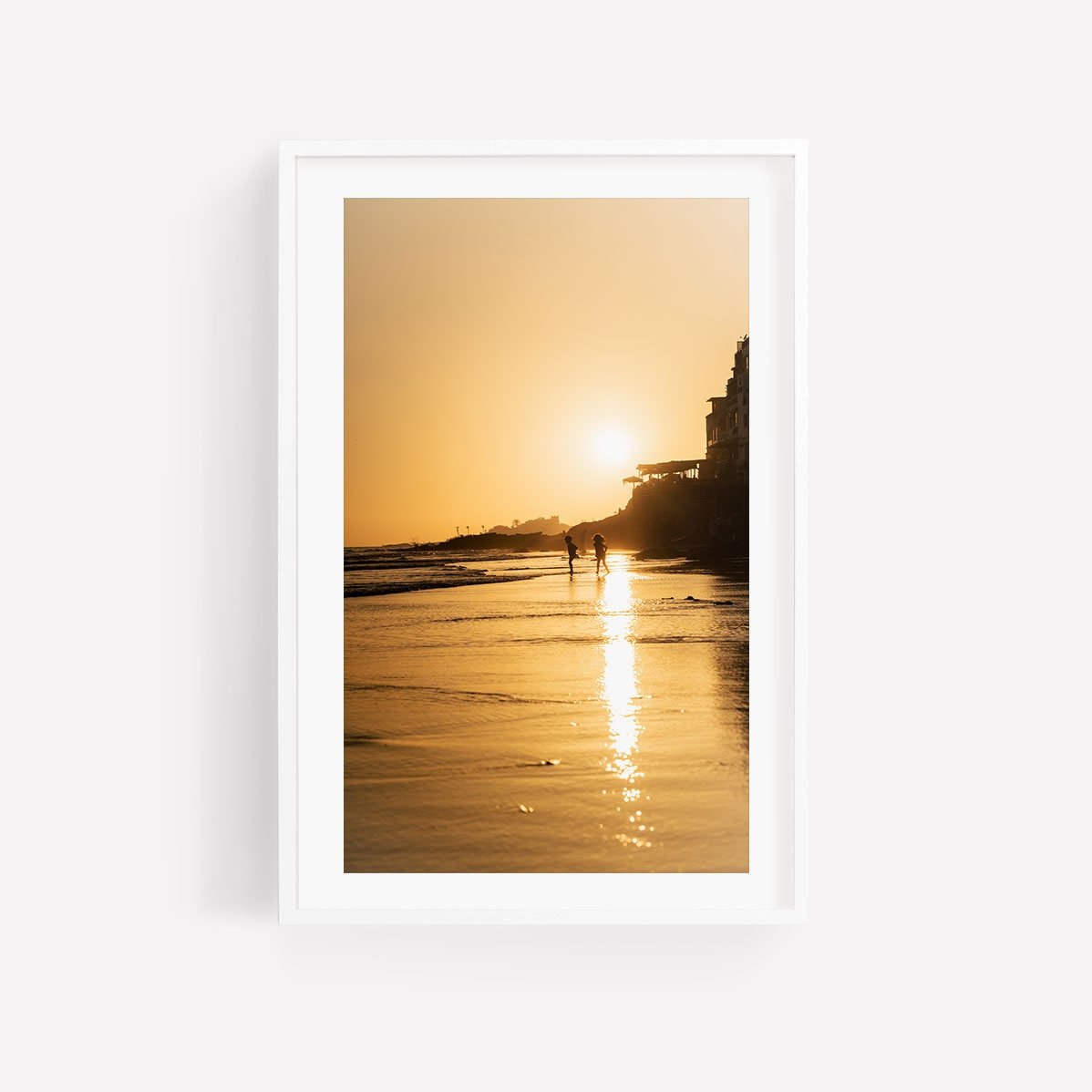Framed photo titled Taghazout Golden Shores: silhouetted couple, beach sunset, sun reflecting on wet sand.